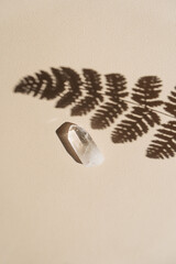 Quartz crystal on beige background, beige miminalist aesthetic, with shadows