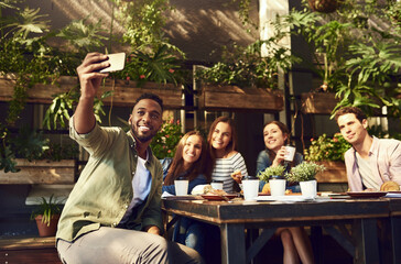 Happy people, coffee and selfie with friends at cafe for photography, picture or memory together. Young, group or employees with smile for social gathering or team building moment at restaurant