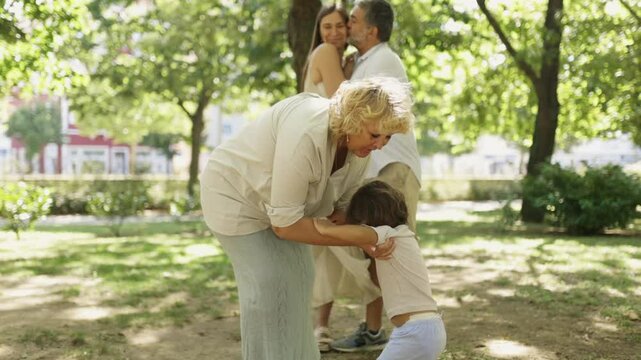 Multi generational family enjoys a sunny day playing together in the park