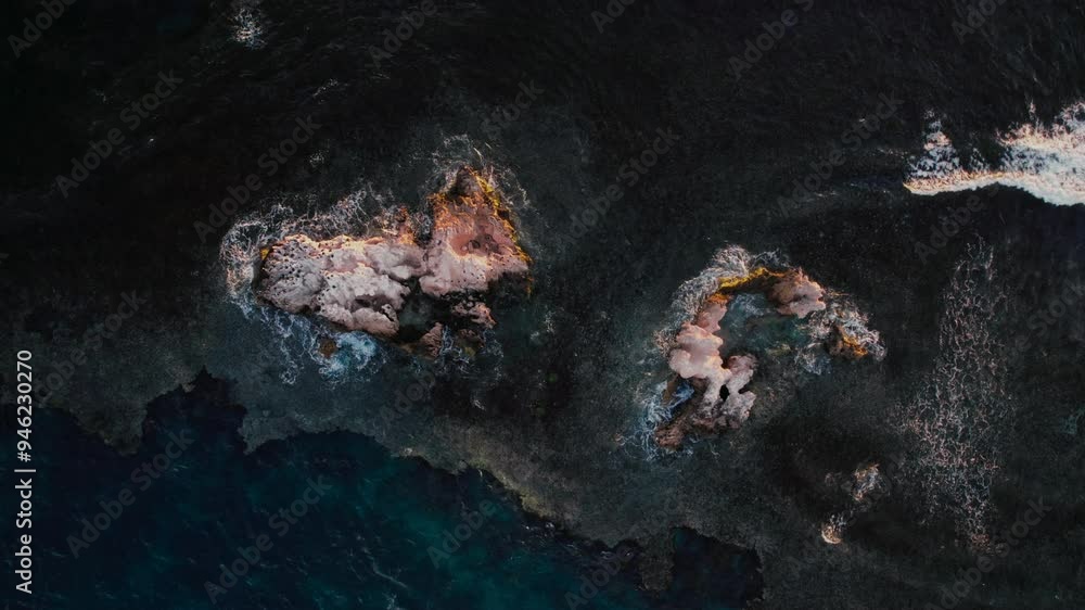 Poster the setting captures an aerial perspective of a rocky coastline where waves crash against formations
