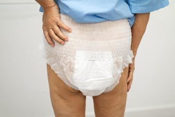 Asian elderly woman wearing diaper for loss of bladder urinary incontinence control.