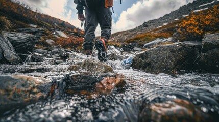 Obraz premium Hiker wearing backpack walking across mountain stream