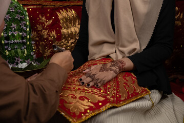 The process of painting henna on the bride's hands. There are many different names for henna tattoo...