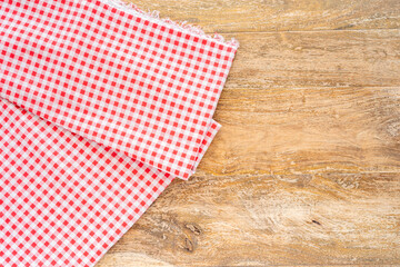 Obraz premium Wooden table and checkered red tablecloth. Top view. 