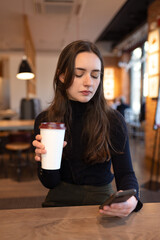 Young woman in restaurant looking at cell phone