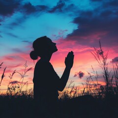 Silhouette of woman praying over beautiful sky background