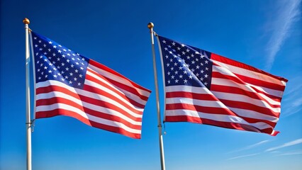 Obraz premium Two American flags crossed at a 45-degree angle, waving gently in the wind, symbolizing patriotism, unity, and national pride on a clear blue sky background.