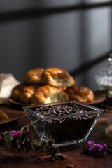 Butter croissants on a wooden plate with ingredients for breakfast or a snack and coffee beans 