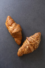 two fresh croissants on a dark background