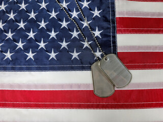 Dog tags rest on an American flag symbolizing patriotism and sacrifice