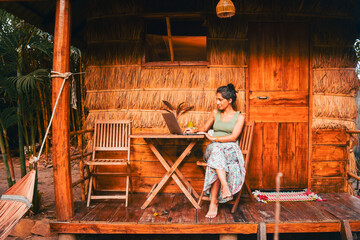 Close up young caucasian hipster woman sit use computer freelance do freelancing work, write travel...