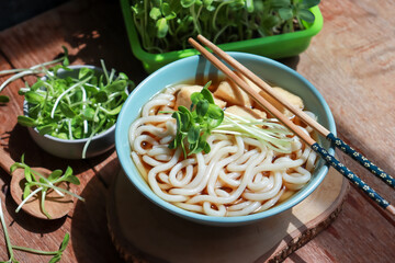 Vegan noodles bowl with tofu and fresh sunflower sprouts. Asian food, vegetarian food, healthy eating.