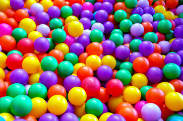 Boy playing on the playground, in the children's maze with balls.