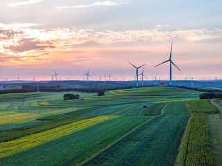 Fototapeta na wymiar view of wind power turbine in field at sunset