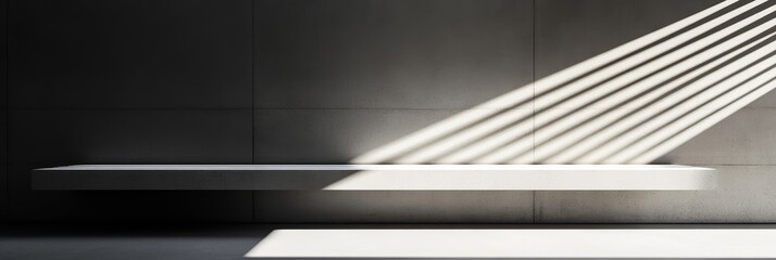 Obraz premium A white shelf showcases striking shadows cast by bright sunlight filtering through a window onto a gray wall