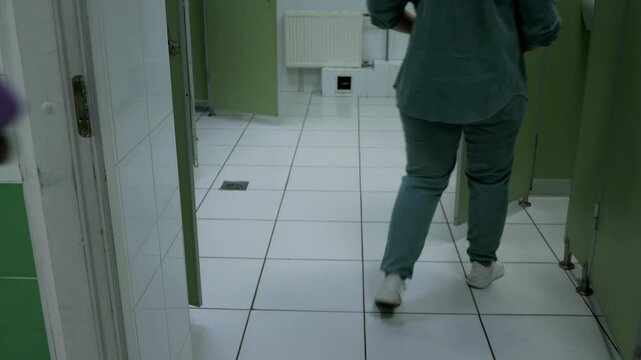 People come and go from the toilet. Women enter public toilets. Restroom interior