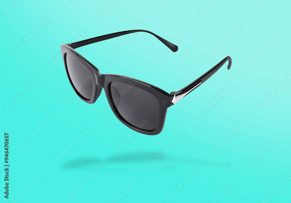 Wall mural Stylish sunglasses in air on turquoise gradient background