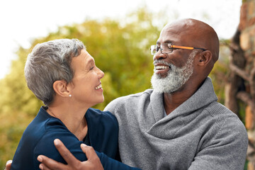 Interracial senior couple, care and love in park, garden or nature for hug or smile together. Happy man, woman and partner for retirement, relax and support for marriage and vacation for pensioner
