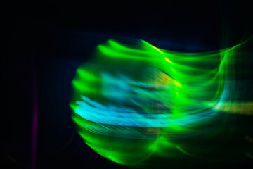 A blurry image of a green and blue object with a purple background. The image has a dreamy, ethereal quality to it, as if it were captured in a moment of suspended animation. The colors are vibrant