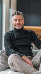 Fototapeta premium A man in a black turtleneck is sitting on a couch