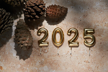 Decorative natural arrangement with golden candles marking the arrival of 2025