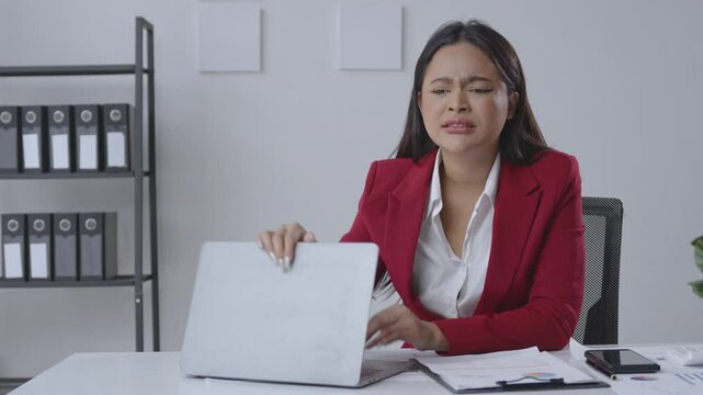Businesswoman is experiencing stress while working at her desk. She is having a hard time concentrating and is feeling overwhelmed