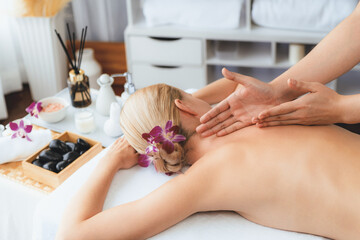 Obraz na płótnie Canvas Caucasian woman customer enjoying relaxing anti-stress spa massage and pampering with beauty skin recreation leisure in day light ambient salon spa at luxury resort or hotel. Quiescent