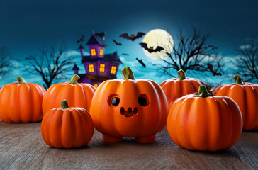 The image features a group of cute, carved pumpkins gathered together in a festive Halloween scene. The central pumpkin has a cheerful, smiling face, and is surrounded by other pumpkins of various siz