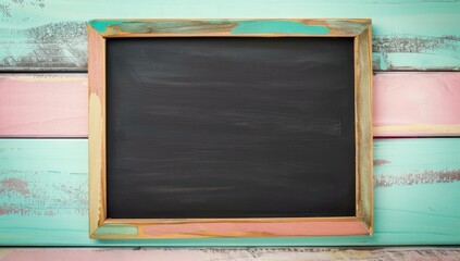 Top view of an empty blackboard on a pastel mint background, framed by wood, perfect for educational settings