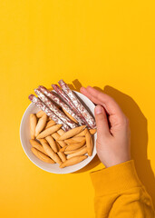 Hand holding bowl with mini fuet and bread sticks