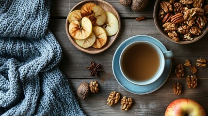 Fototapeta premium A flat lay of a cozy autumnal snack, featuring spiced roasted nuts, dried apple slices, and a warm mug of spiced chai
