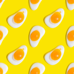 Seamless pattern with gummy fried egg on yellow background.