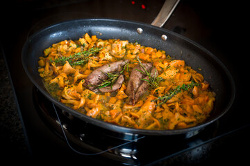 ready to eat - roasted tenderloin from a roebuck with chanterelles, paprika and herbs in butter