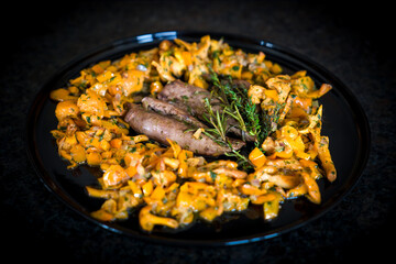 ready to eat - roasted tenderloin from a roebuck with chanterelles, paprika and herbs in butter