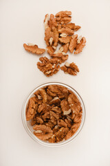 Walnuts in a plastic jar on a white background.
