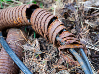 Obraz premium Destroyed protective metal corrugated pipe of electric cable