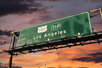 Los Angeles route 101 and 110 overhead freeway sign in Southern California with sunset sky.