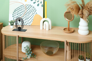 Shelving unit with painting, pampas grass and decor near green wall in room, closeup