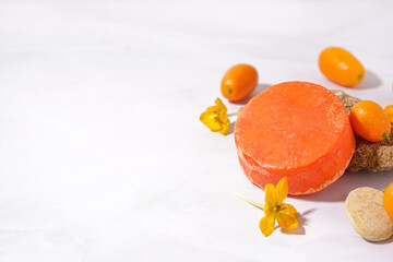 Handmade solid shampoo, flowers and kumquats on light background, closeup