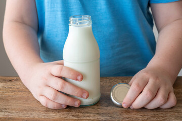 Bottle of milk in the hands of a child.