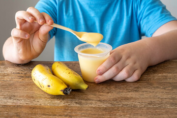 Banana yogurt in the hands of a child.