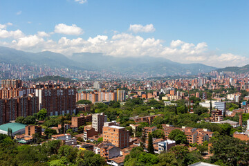Obraz premium Beautiful panorama (cityscape) of Medellin, Medellín, on a sunny day. The pictures shows condominiums and the Andes Mountains. Antioquia, Colombia. Blue sky, white clouds.