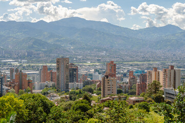 Obraz premium Beautiful panorama (cityscape) of Medellin, Medellín, on a sunny day. The pictures shows condominiums and the Andes Mountains. Antioquia, Colombia. Blue sky, white clouds.