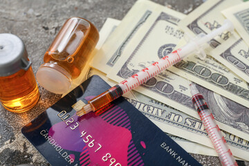 Ampules with drugs, syringes, credit card and money on grunge background, closeup