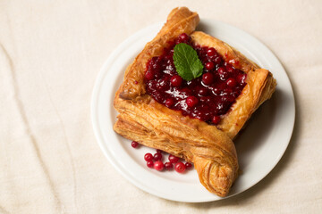 A delicious dessert, puff pastry cake with berry filling on a light color