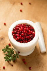 A mortar full of ripe wild lingonberries, on a wooden background