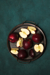 Juicy red apples in a vintage tray on a green background