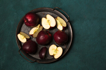 Beautiful red apples in a vintage tray on a green background