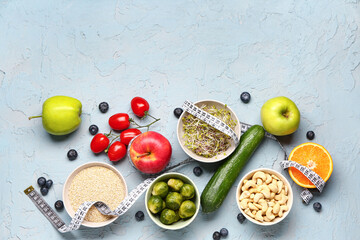 Composition with healthy food and measuring tape on blue grunge background. Diet concept