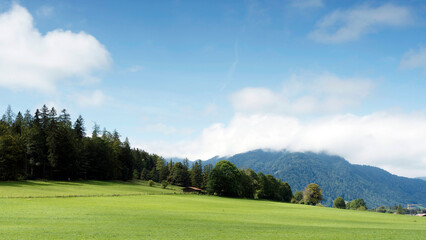 Bayerische Berglandschaft. Grüne Wiesen am Fuße des Wallbergs „Unterwallberg“ mit Blick auf den Hirschberggipfel und das Tegernseer Tal